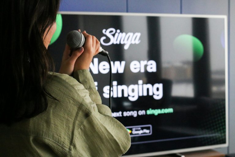 A woman sings karaoke into a microphone.